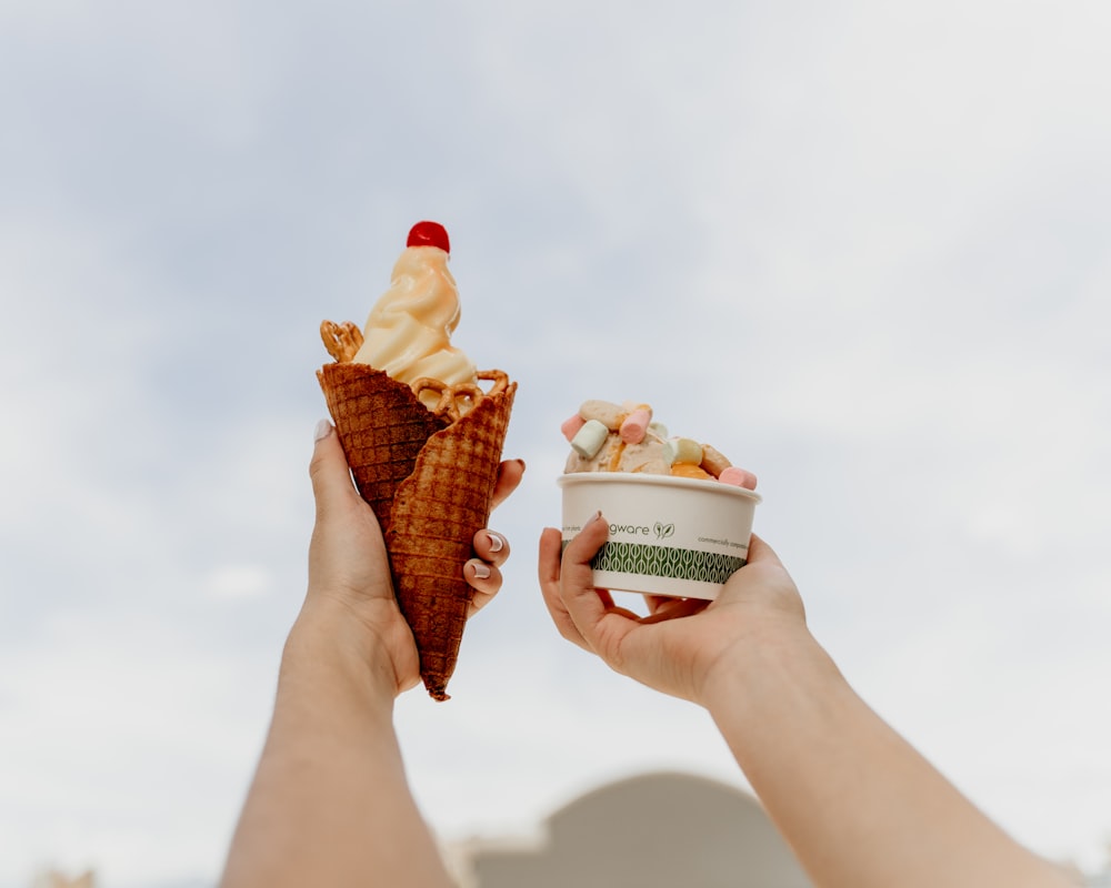 pessoa segurando cone de sorvete com cone