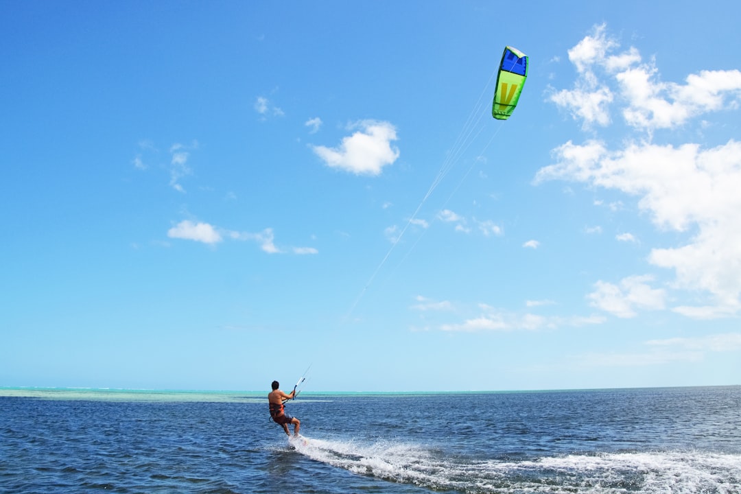 man in red shorts surfing on sea during daytime