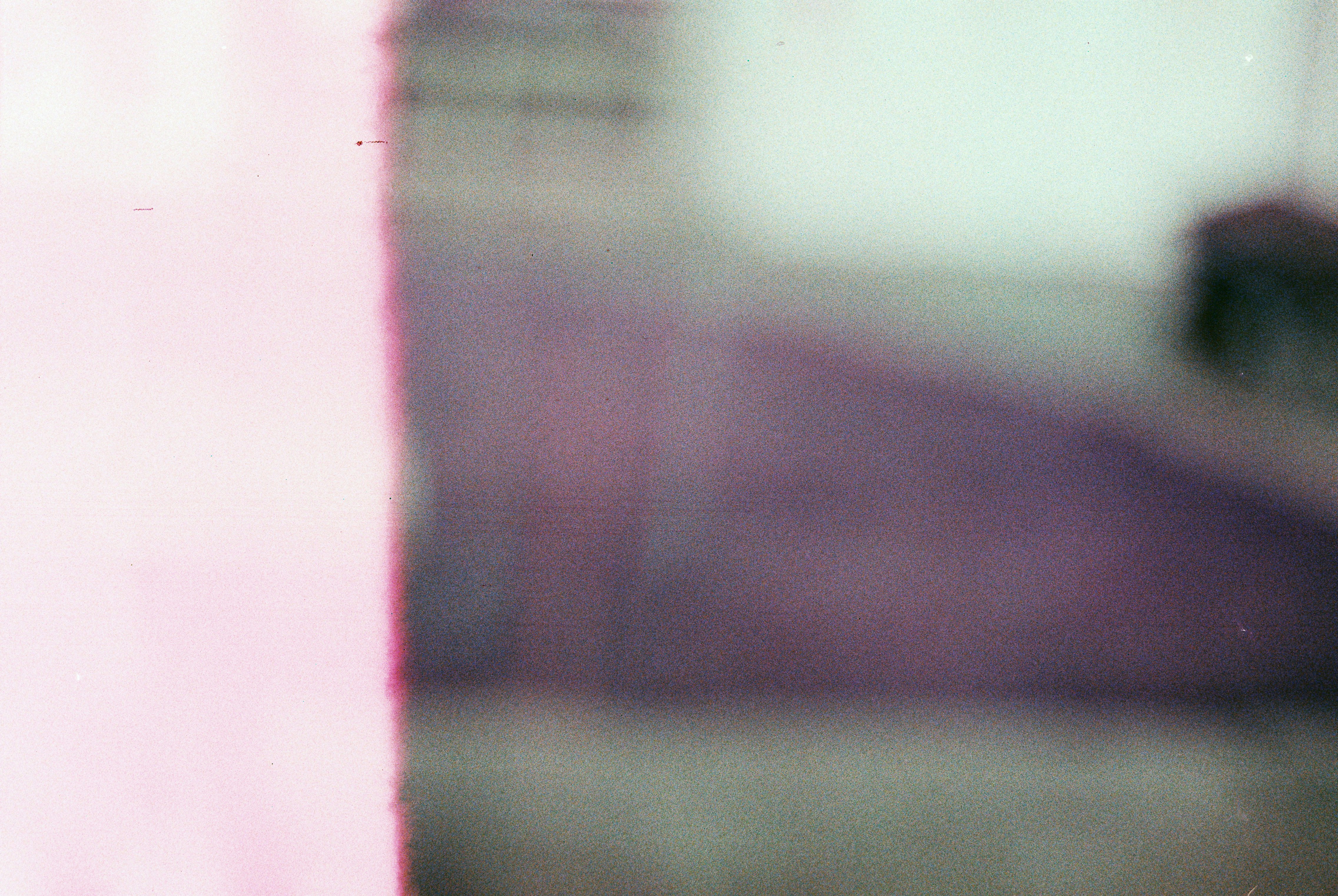 Close-up of a film cell with a blurred image and pale pink edge.