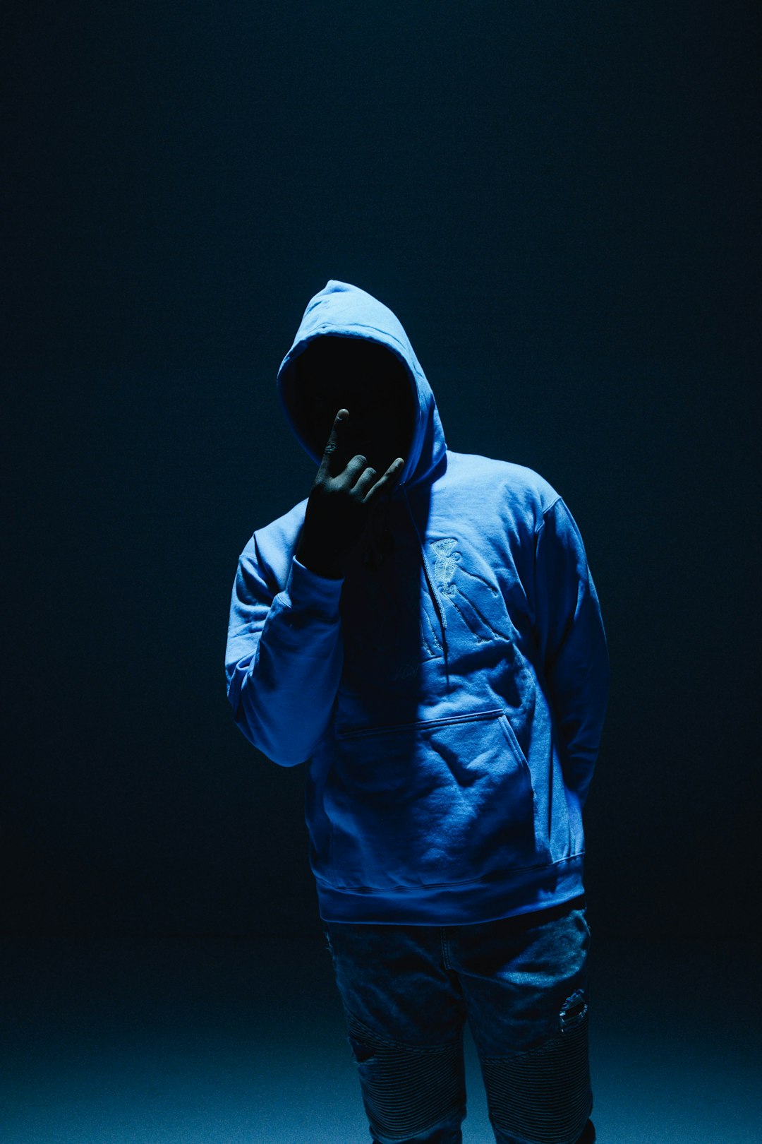 man in blue hoodie standing