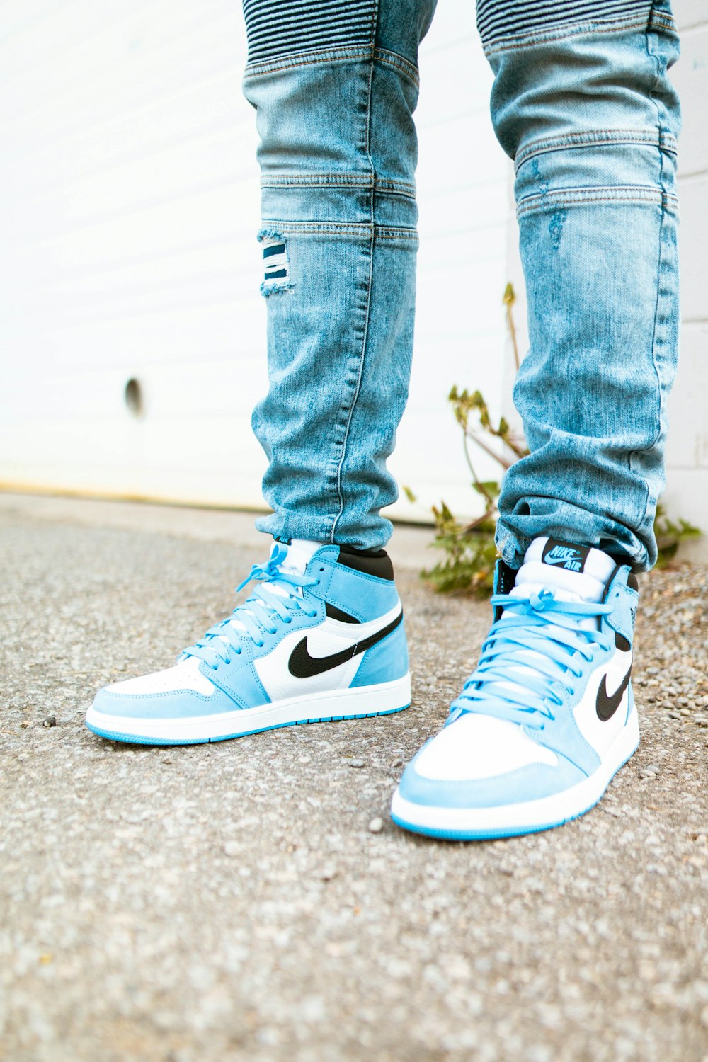 person in blue denim jeans and blue and white nike sneakers