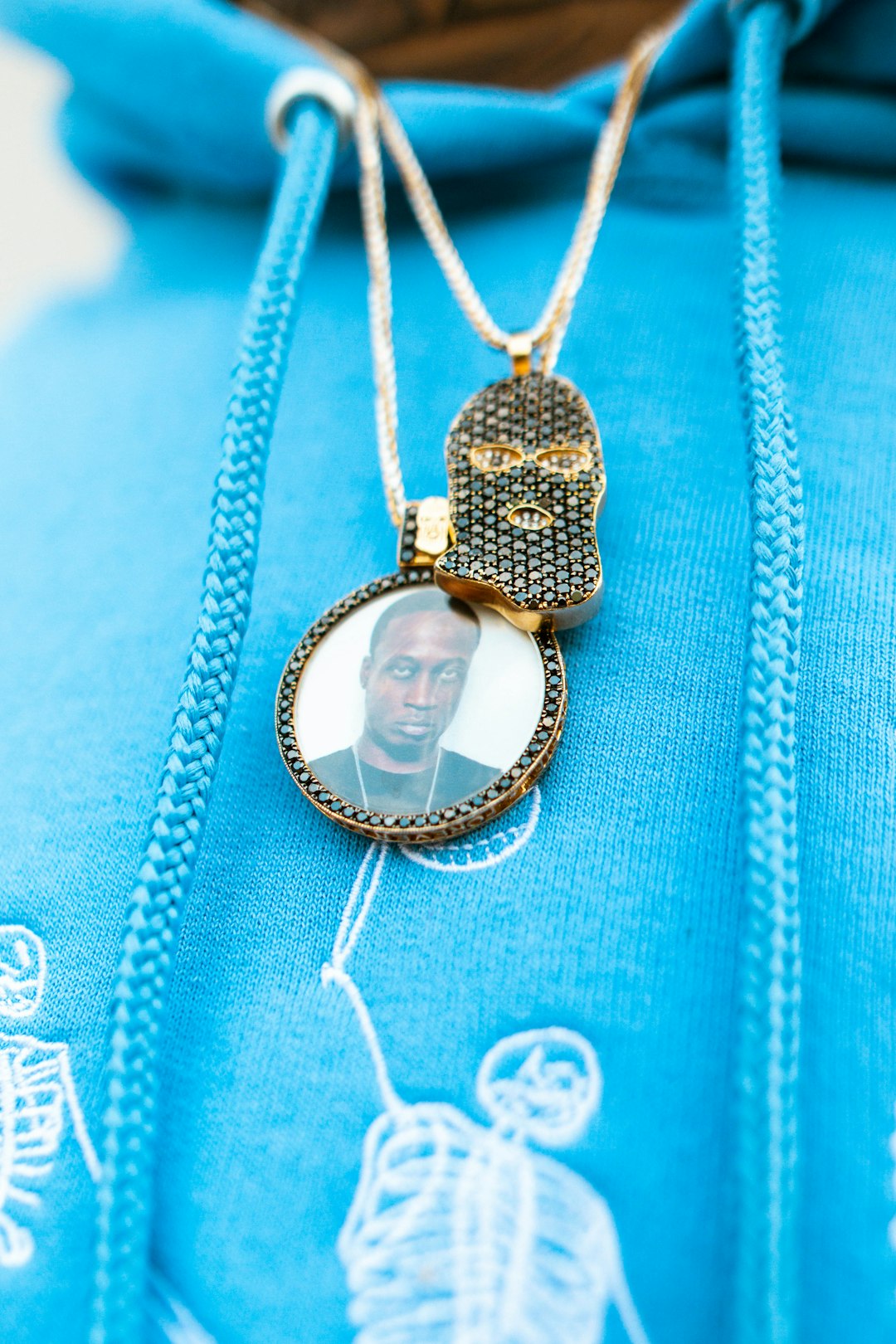 gold and silver necklace on blue textile