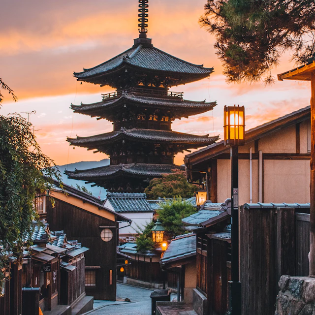 A traditional pagoda rising above a narrow street in Kyoto, Japan, at golden hour