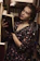 woman in black and red floral dress holding book