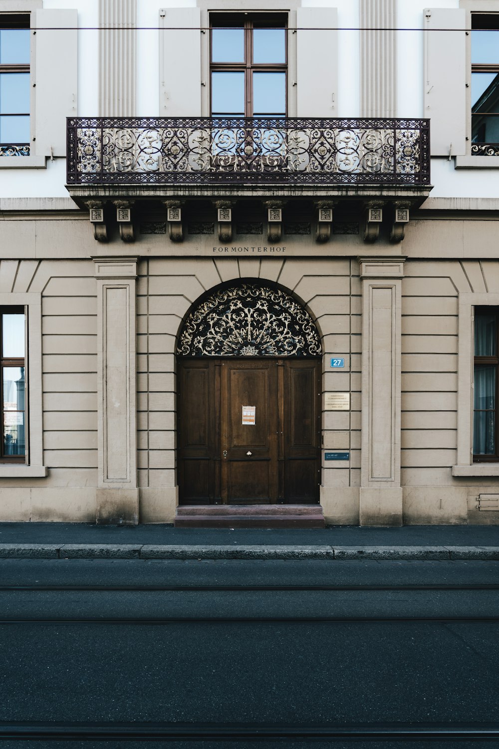 brown wooden door on white concrete building