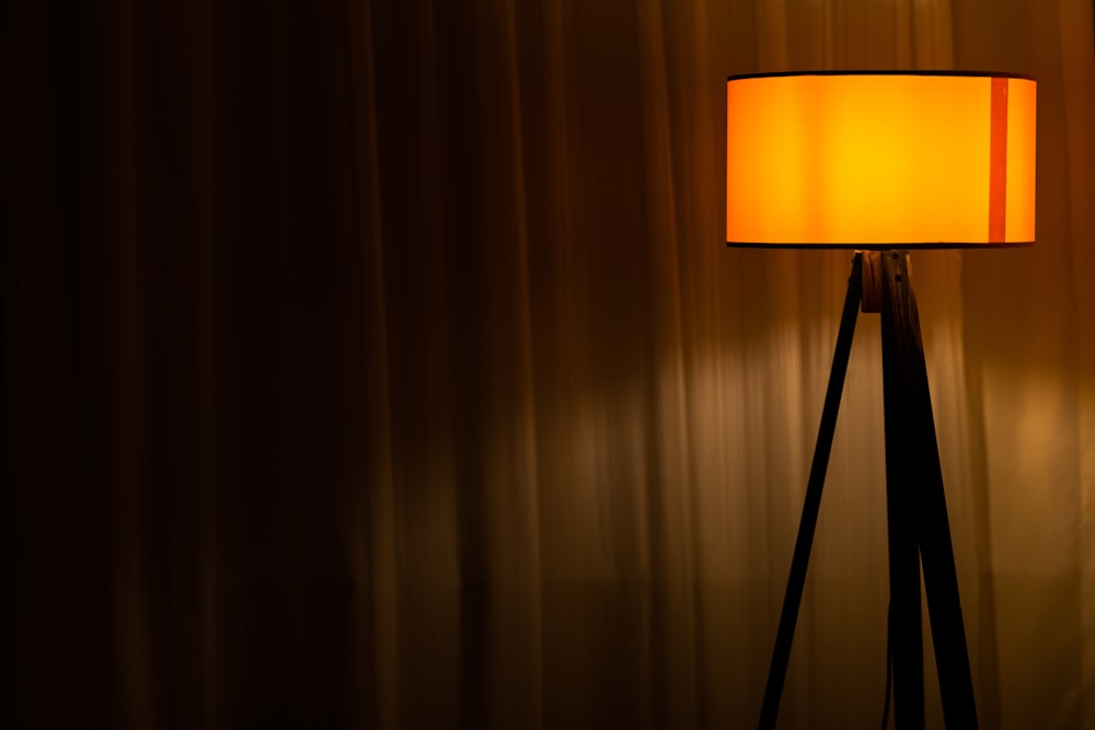 Lámpara de mesa marrón encendida cerca de la cortina marrón