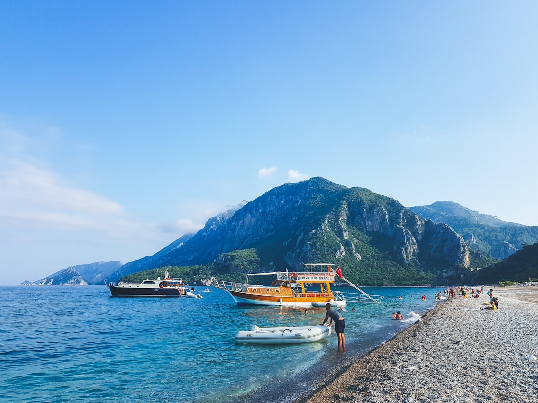 people on beach near mountain during daytime