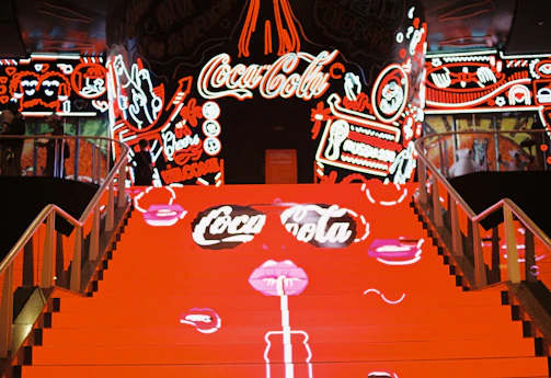 A futuristic digital staircase glowing with neon pink, tinto, and orange lights, symbolizing the interactive journey of Chitovzky's games.