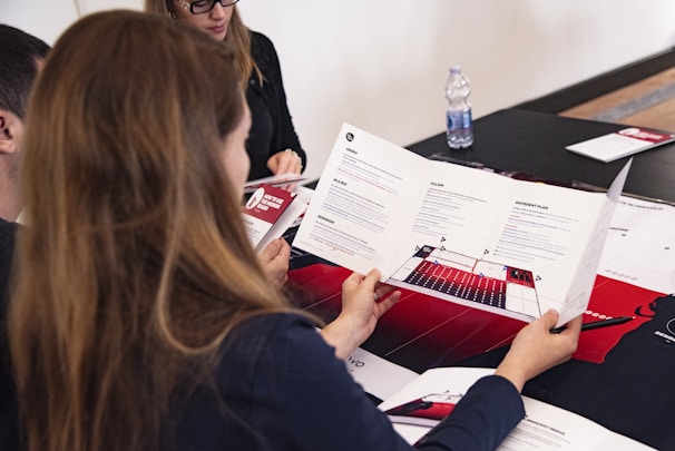 A diverse group of people gathered around a table, reviewing documents and discussing transparency initiatives.