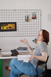 woman in gray shirt sitting on chair holding white ceramic mug