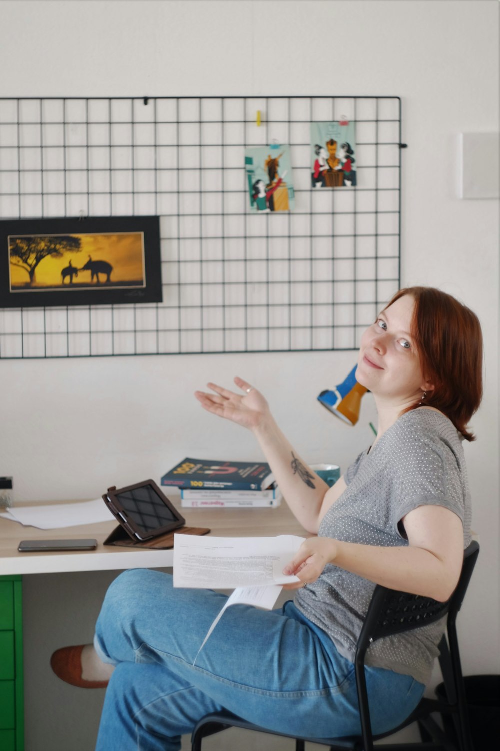 woman in gray shirt sitting on chair holding white ceramic mug