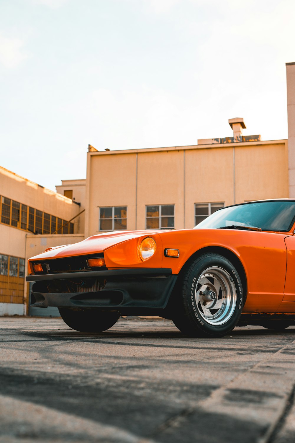 orange chevrolet camaro parked on roadside during daytime