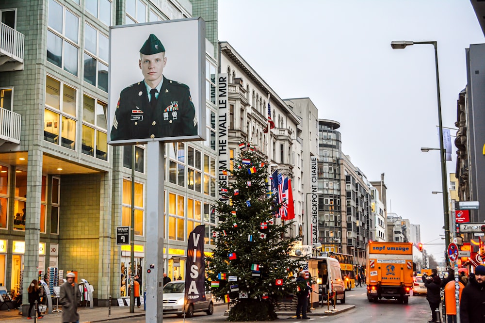 man in black suit standing near christmas tree