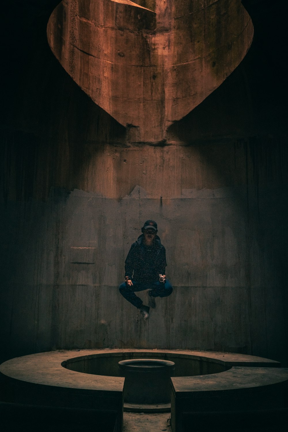 man in black jacket and black pants sitting on tunnel