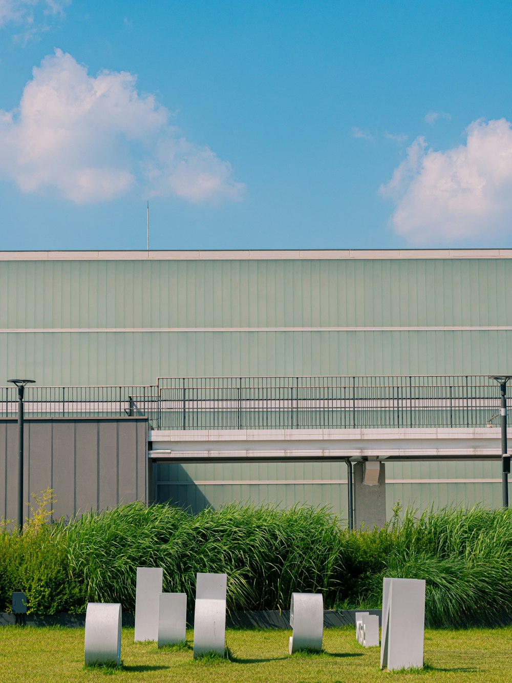 white building with green grass and white metal fence