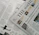 A section of a newspaper is placed over an open magazine. The newspaper displays a headline about the distribution of ex gratia finance and includes several smaller images and text flags. The magazine features articles and highlights, including historical and political content, with images and diagrams accompanying the text. The overall composition suggests a mix of current news and historical retrospectives.