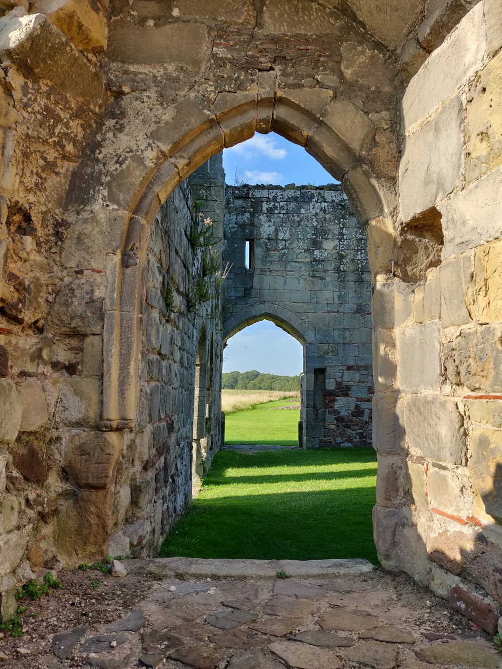 brown brick arch on green grass field during daytime