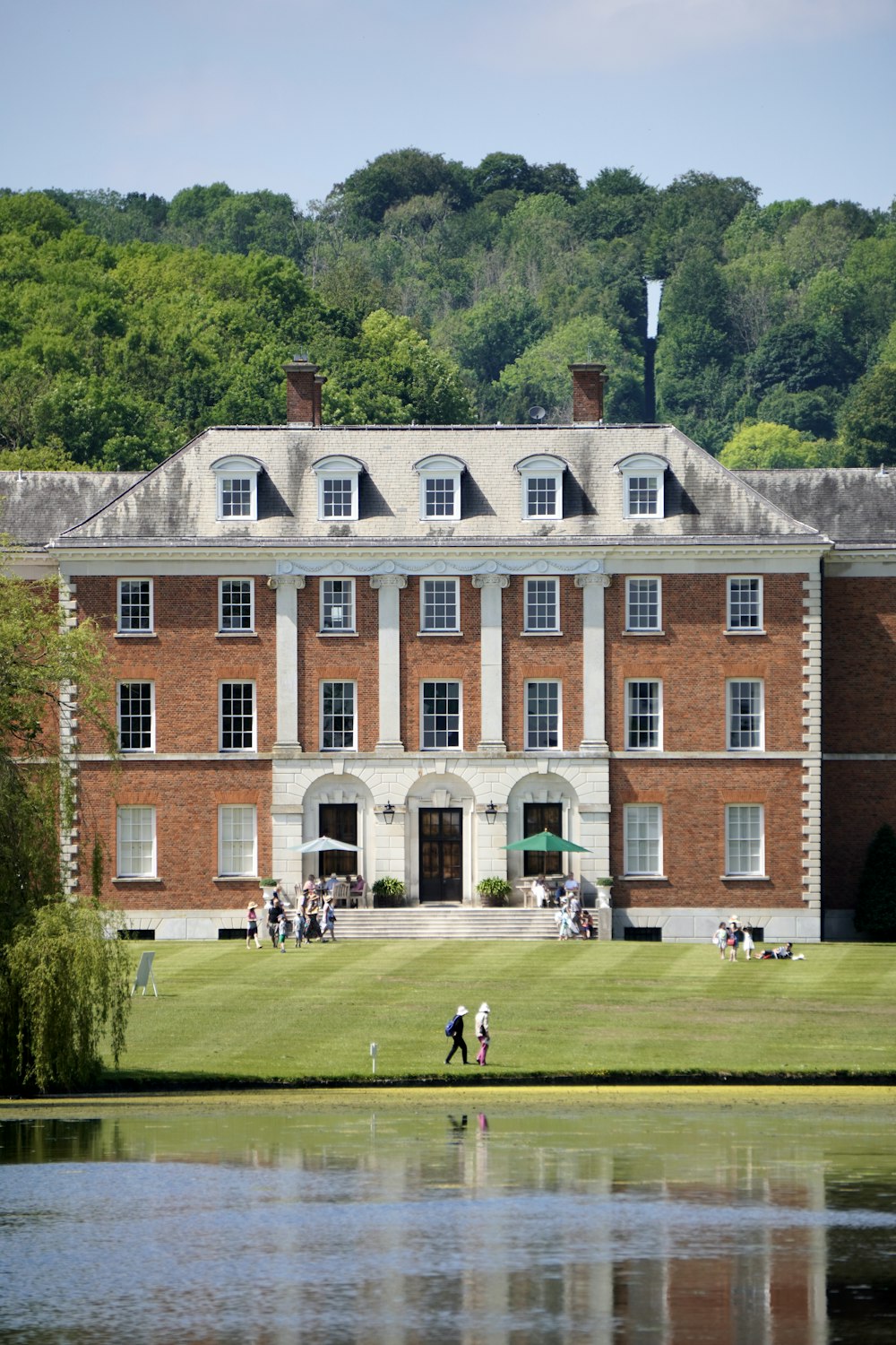 people walking on green grass field near brown concrete building during daytime