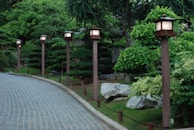A serene garden path lined with old trees and vintage lanterns, perfect for a peaceful Heilzeitreise.