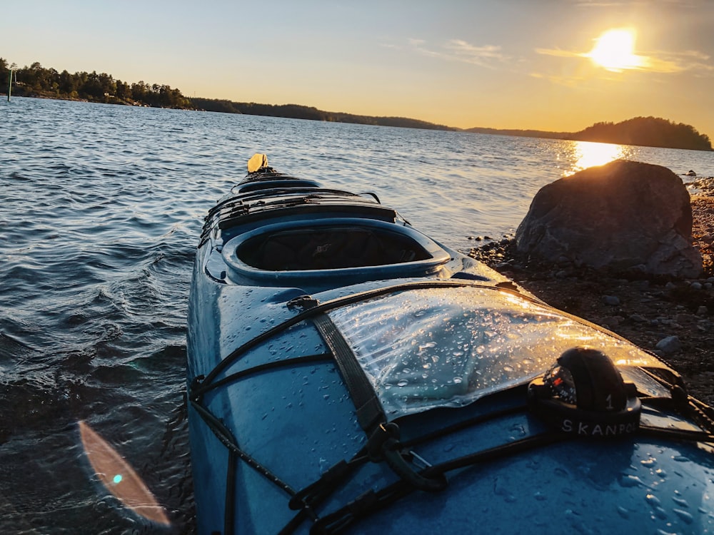 blue and yellow kayak on sea during sunset