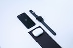 Close-up of sleek modern gadgets including headphones and smartwatches on a clean white surface.