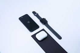 Close-up of popular electronic devices like headphones, smartphones, and smartwatches arranged neatly.