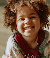 girl in red and white knit sweater smiling