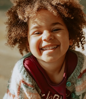 girl in red and white knit sweater smiling