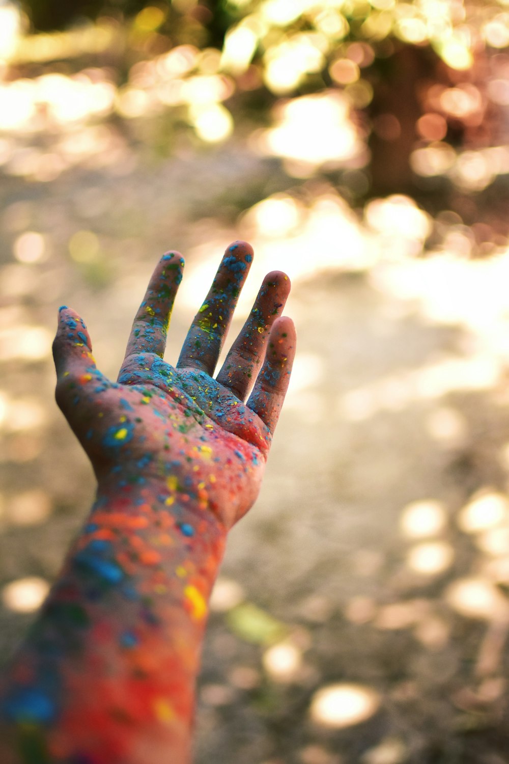 Person mit blaugrüner und roter Farbe zur Hand