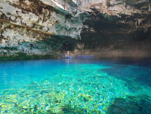 Tourists enjoying a peaceful moment by the crystal-clear waters of the Jeita Grotto