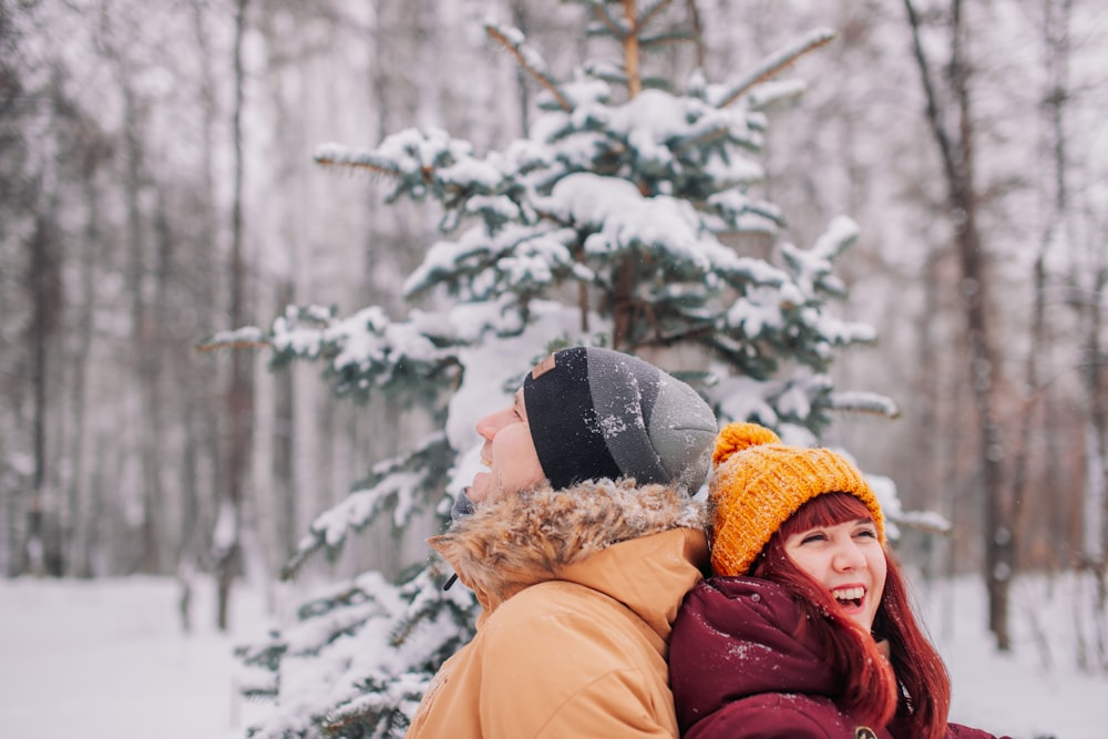 woman in brown coat wearing gray knit cap and brown knit cap