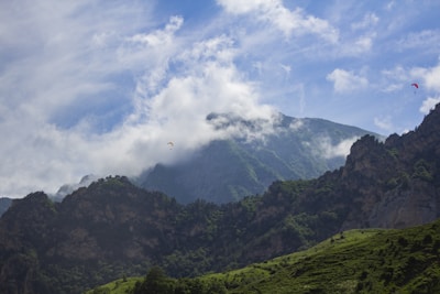 A panoramic view of paragliders floating peacefully above Taiwan’s green hills.