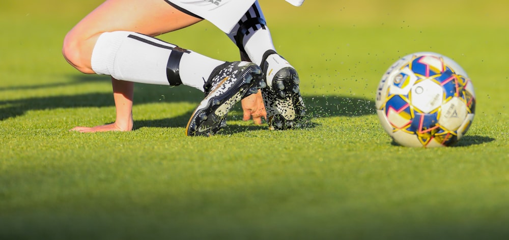 person in black and white jersey shirt and black pants playing football