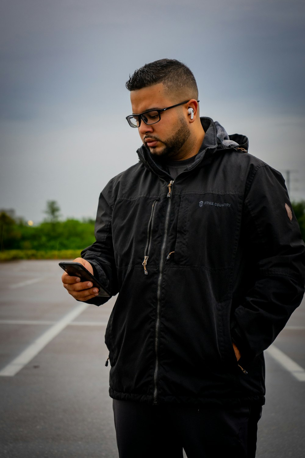 man in black leather jacket holding smartphone