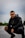 man in black jacket and black pants sitting on road during daytime