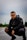man in black jacket and black pants sitting on road during daytime