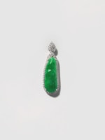 A pendant featuring an elongated green gemstone set within a detailed silver or platinum setting, encrusted with small, sparkling stones around the perimeter. The pendant is suspended from an intricate floral-shaped bail, also adorned with sparkling stones.