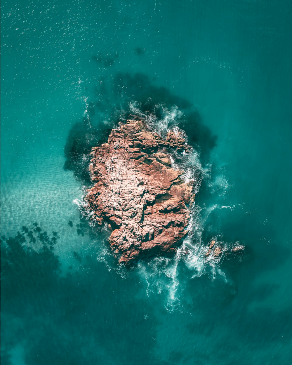 brown rock formation on body of water during daytime