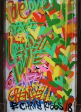 A vibrant graffiti artwork with overlapping words and shapes. The background is filled with multicolored hearts and an array of dynamic, abstract patterns. The text includes words like 'love' and 'peace', skillfully integrated into the composition.
