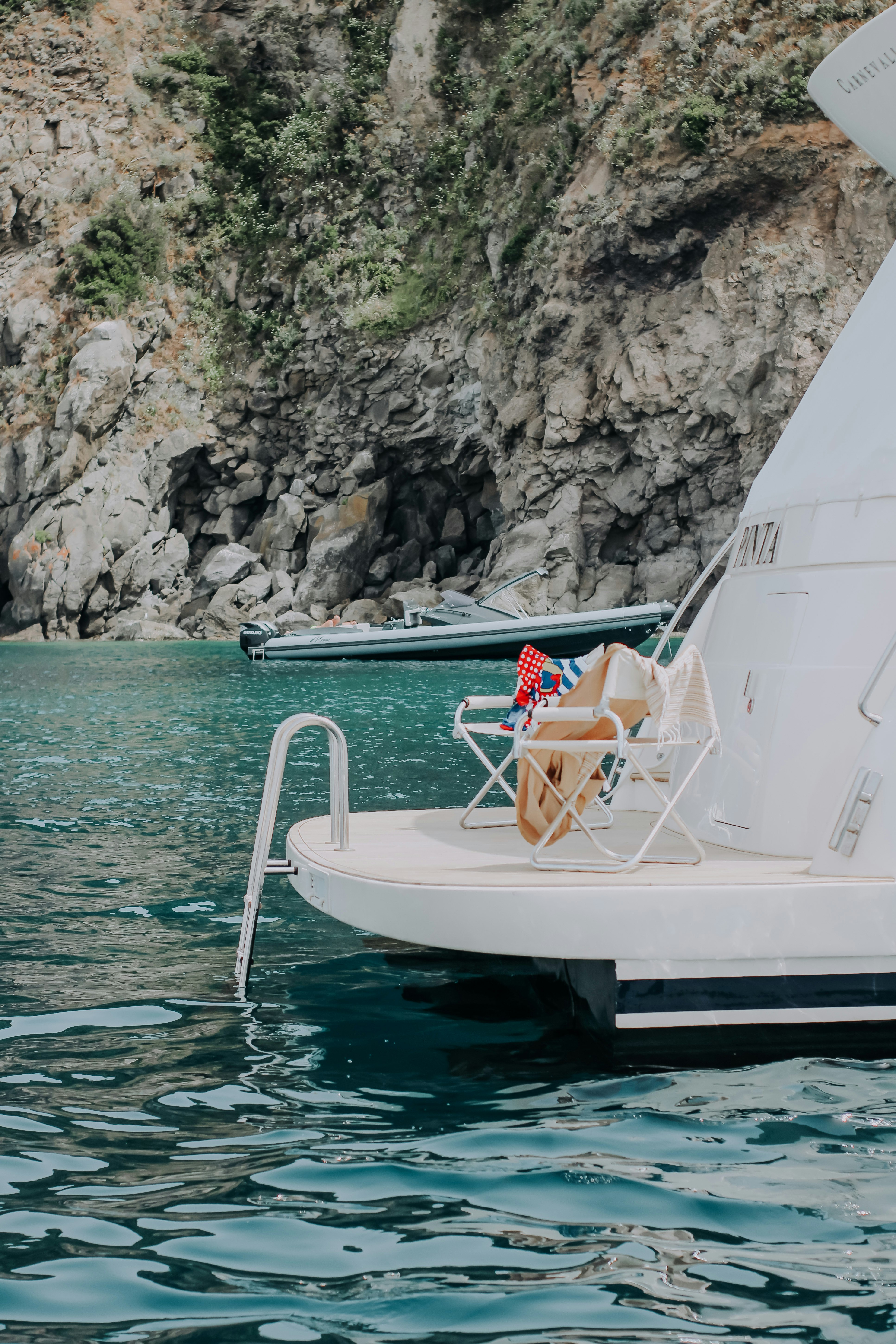 woman in white and red bikini sitting on white boat on water during daytime