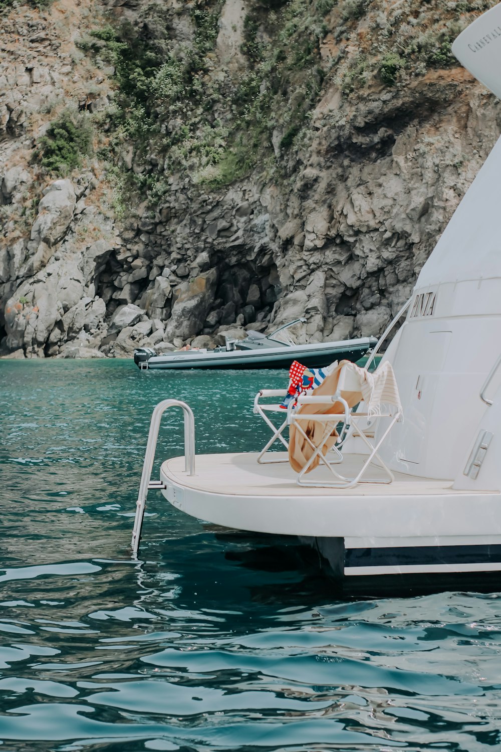 woman in white and red bikini sitting on white boat on water during daytime