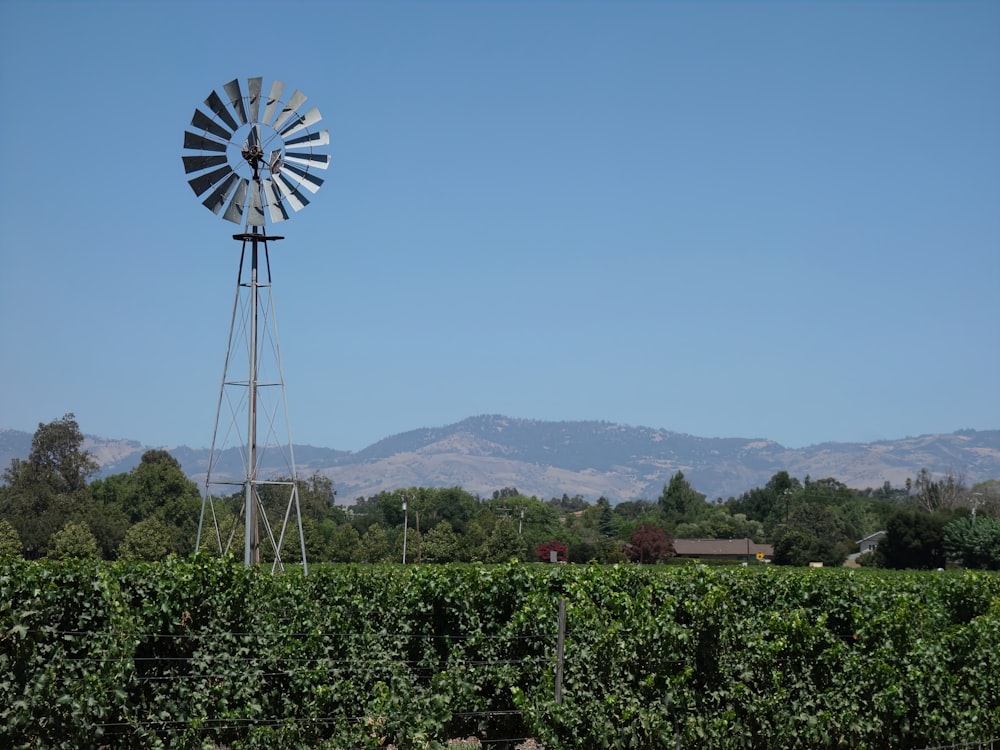 a windmill in a field with mountains in the background