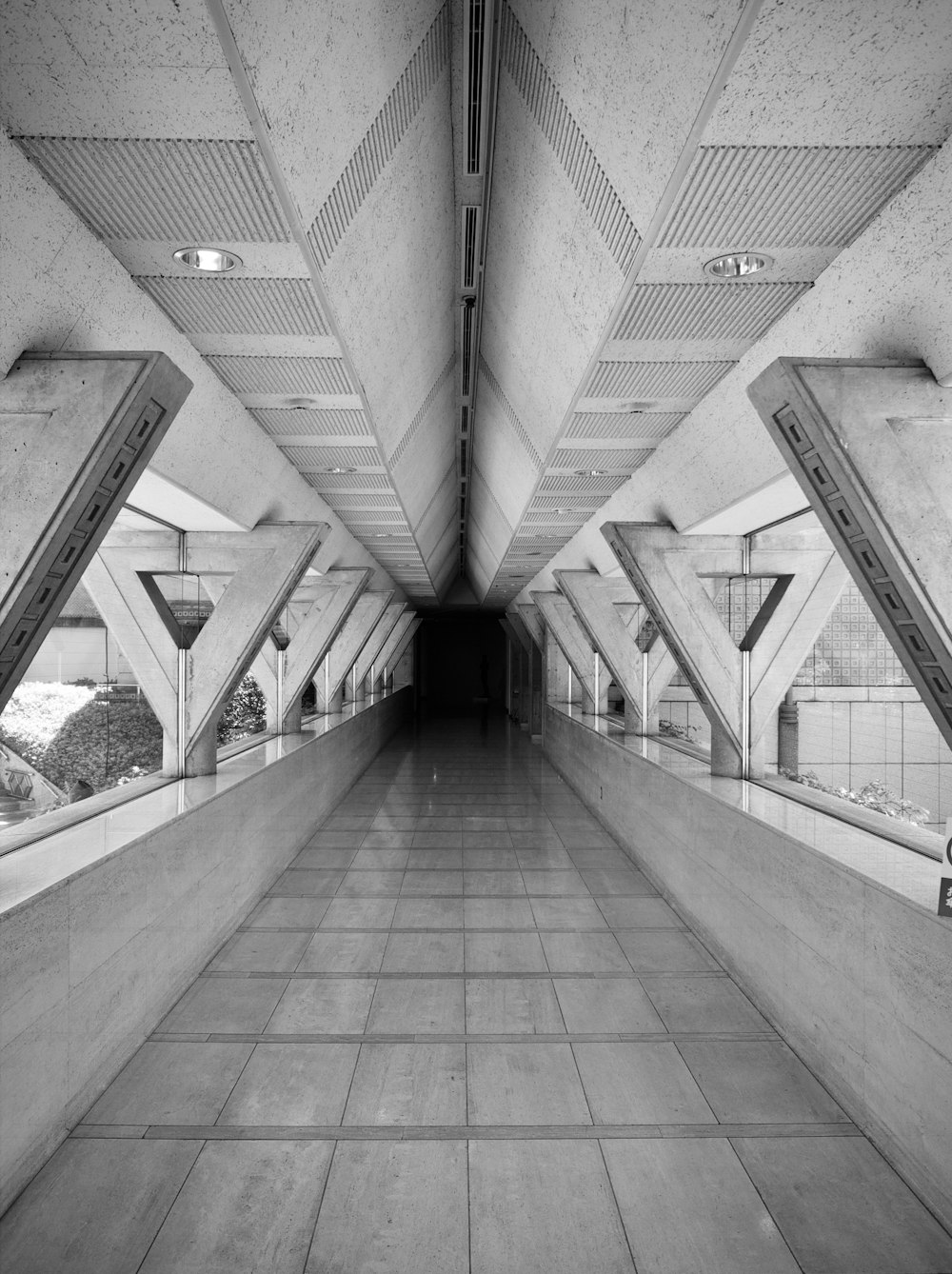 Photo en niveaux de gris d’un homme marchant dans un couloir