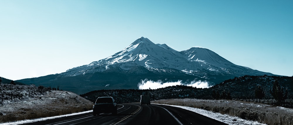 black car on road near snow covered mountain during daytime