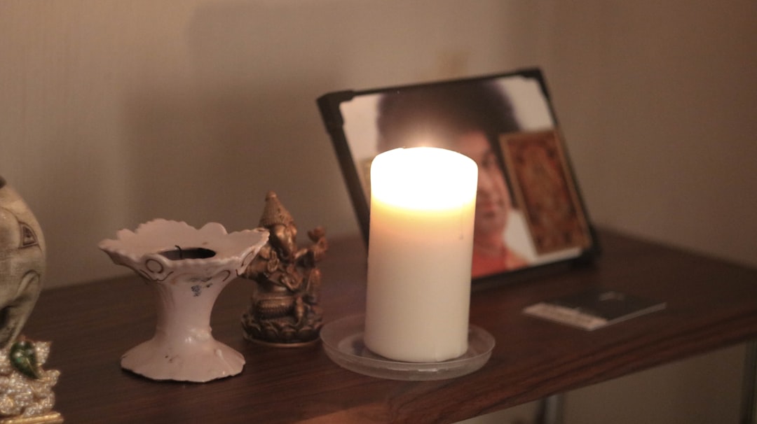 white pillar candle on brown wooden table