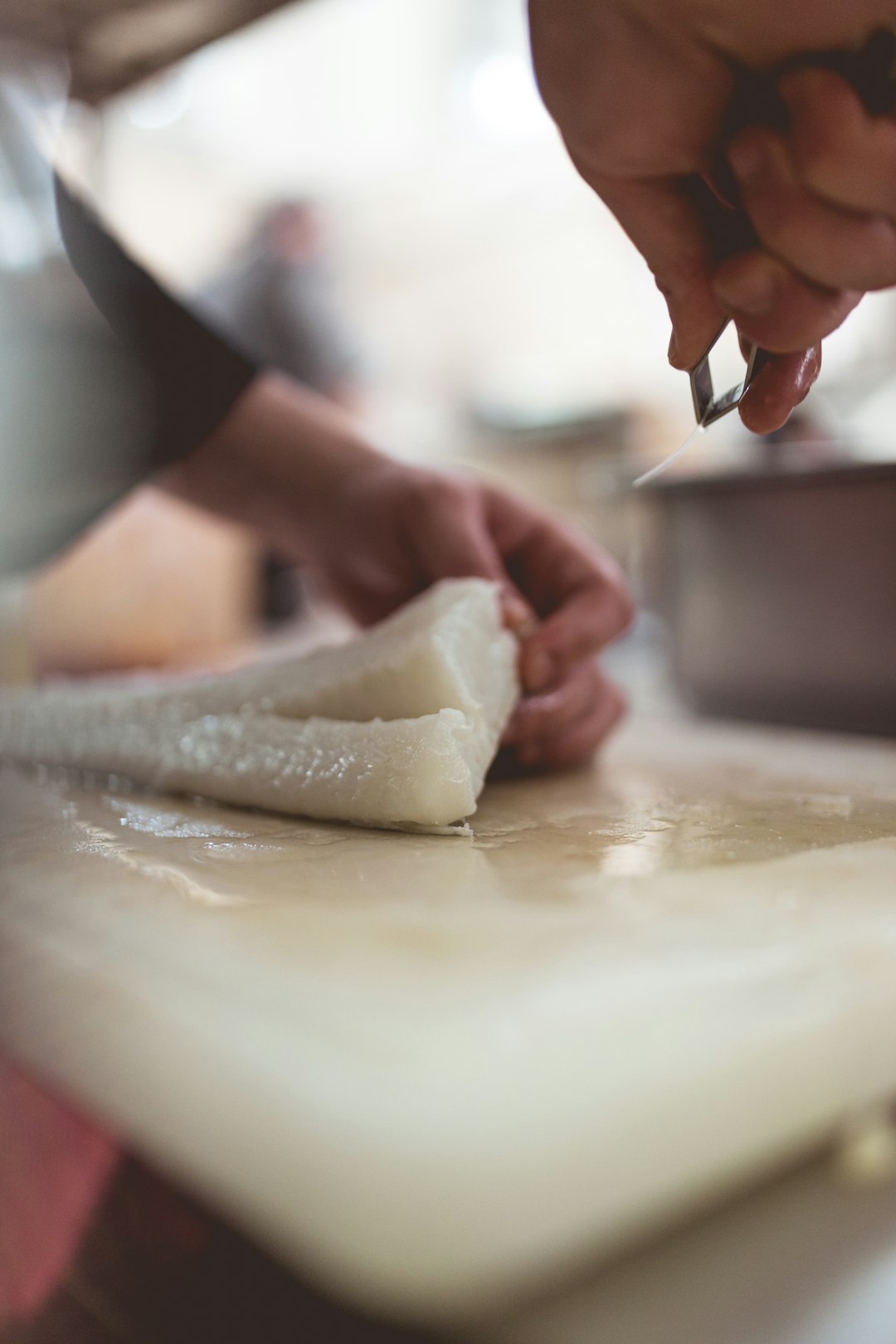 person holding white dough on white table