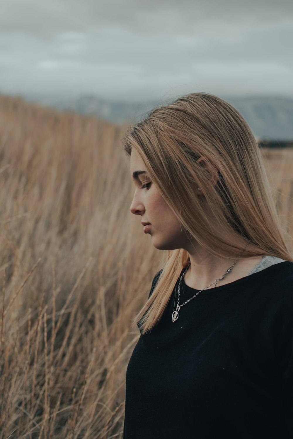 woman in black shirt standing on brown grass field during daytime