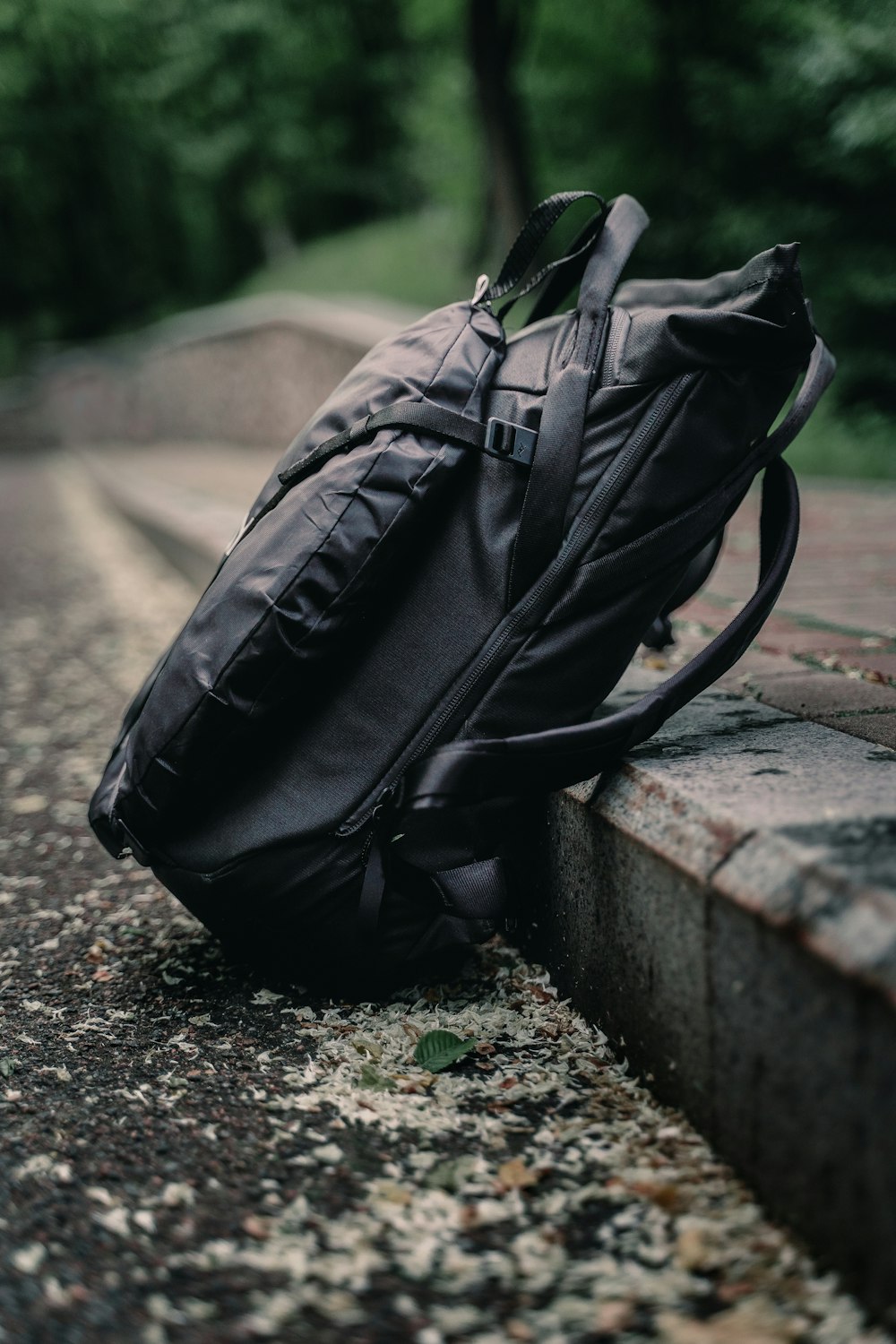 black leather backpack on gray concrete bench