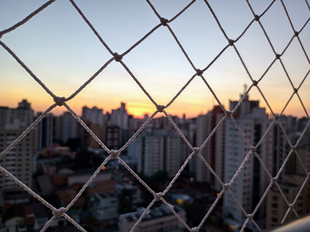 grey metal fence near high rise buildings during sunset