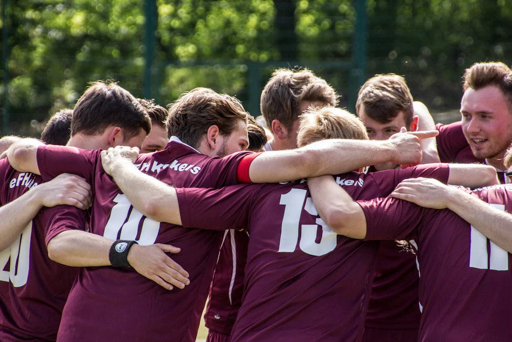 A team huddled together, arms around each other